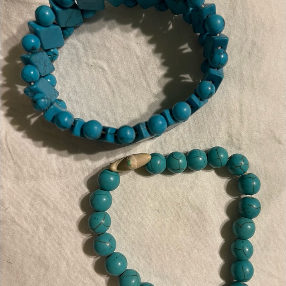 Two Turquoise colored bead bracelets stretch casual and fun one with a starfish